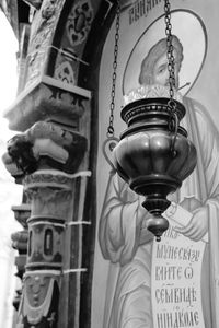 Low angle view of electric lamp hanging on metal