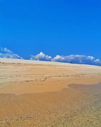 Scenic view of desert against blue sky