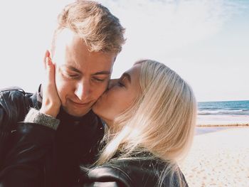 Close-up of young couple kissing on beach