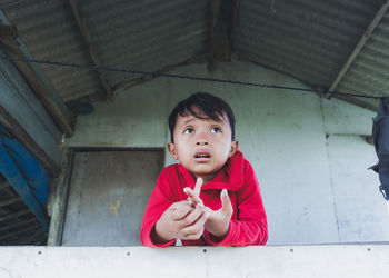 Portrait of boy standing against wall