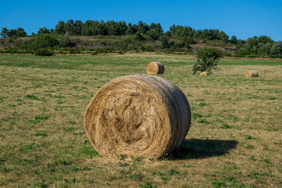 Hay bales on field against sky