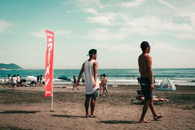 People on beach against sky