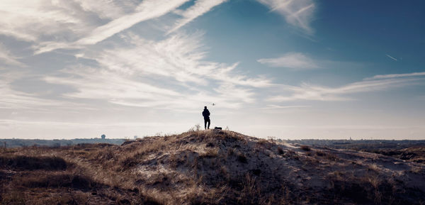 Men on landscape against sky