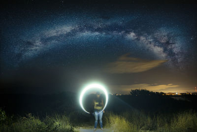 Digital composite image of man on field against sky at night