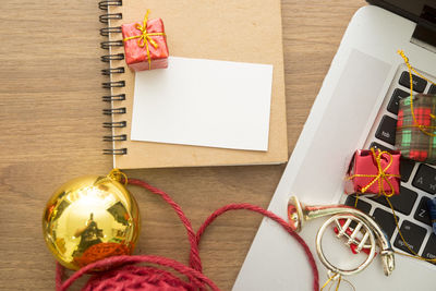 High angle view of christmas presents with laptop on table