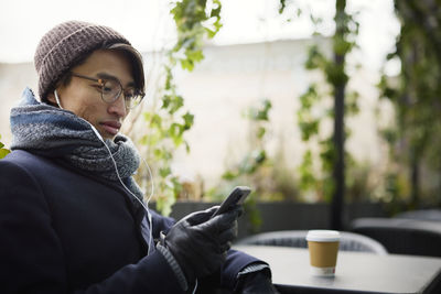 Man using cell phone in outdoor cafe