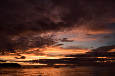 Scenic view of sea against dramatic sky during sunset