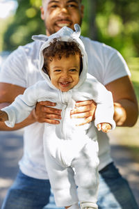 Portrait of happy with holding son on road