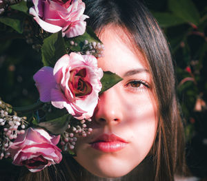 Close-up of woman with pink flower