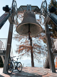 Low angle view of bicycle by trees against sky