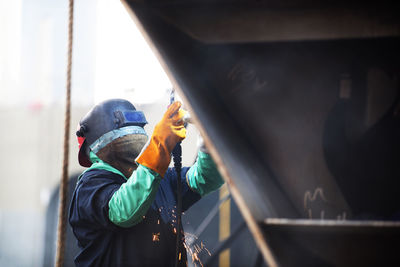Worker welding container ship at industry