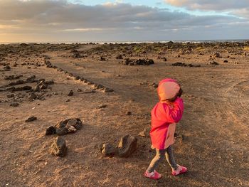 Side view of girl walking in barren field