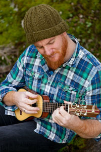 Midsection of man playing guitar