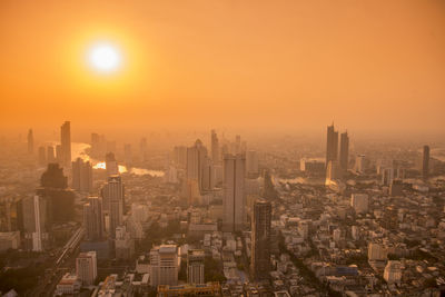 Aerial view of buildings in city during sunset