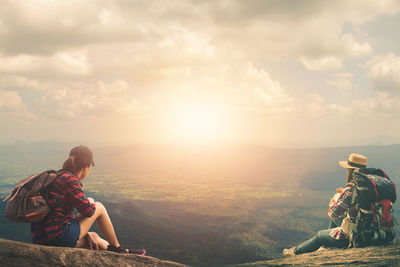 People looking at mountains against sky