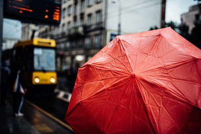 Close-up of red umbrella at railroad station during rainy season