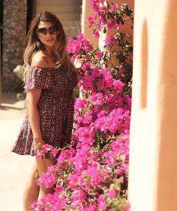 Portrait of beautiful woman standing by flower plant