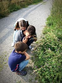 High angle view of siblings looking at plants