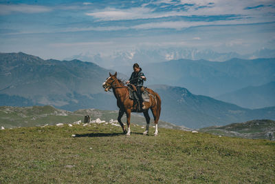 Boy sitting on horse at mountain