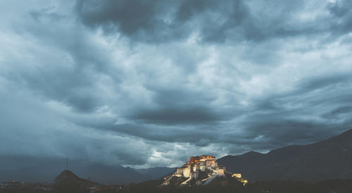 Low angle view of buildings against cloudy sky