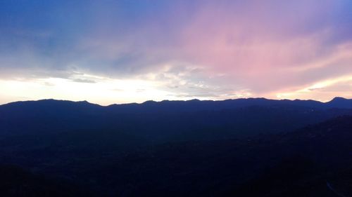 Scenic view of silhouette mountains against sky at sunset