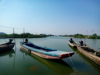 Boats moored on sea against clear sky