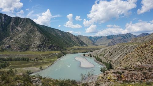 Scenic view of river amidst mountains against sky