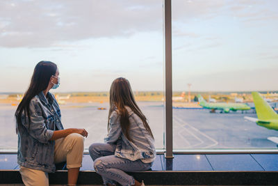 Woman sitting on floor against sky