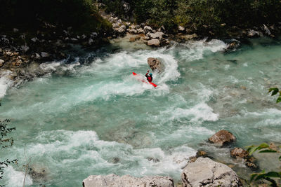 Rear view of man surfing in river