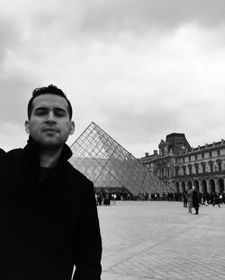 Portrait of man in city against sky