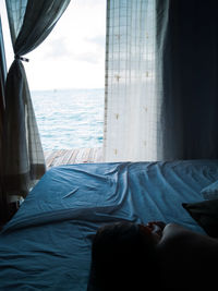 Rear view of girl relaxing on bed in hotel