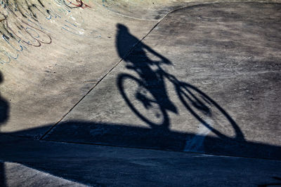 Shadow of person riding bicycle