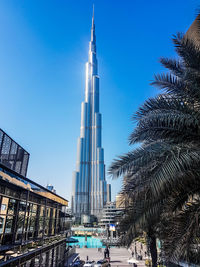 Low angle view of skyscrapers against blue sky