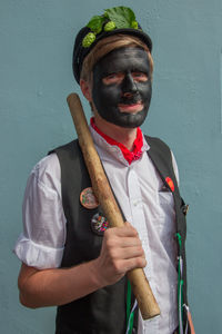 Portrait of young man standing against wall