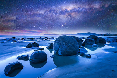 Scenic view of snow against sky at night