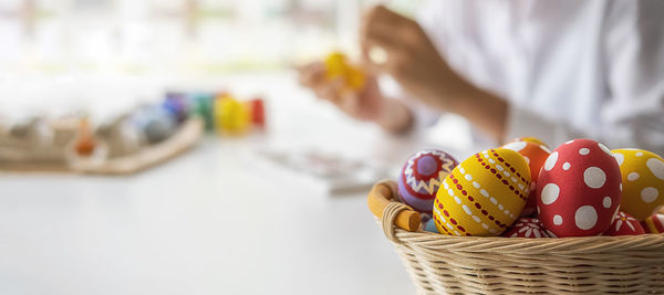 Close-up of hand holding ice cream in basket on table