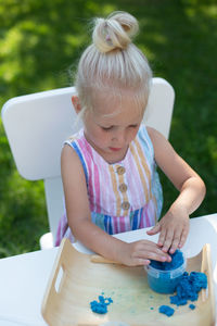 Cute girl holding ice cream on table