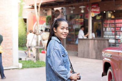 Portrait of smiling young woman in city