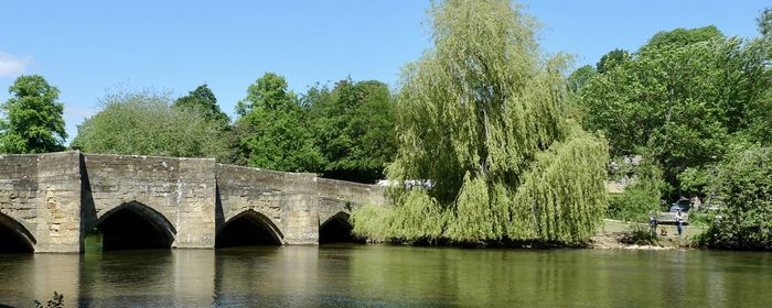 Arch bridge over river against sky