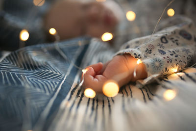 Cropped hand holding illuminated light bulb