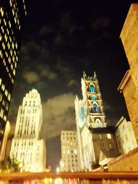 Low angle view of illuminated buildings against sky at night