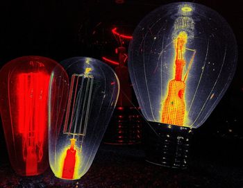 Close-up of illuminated lighting equipment against black background