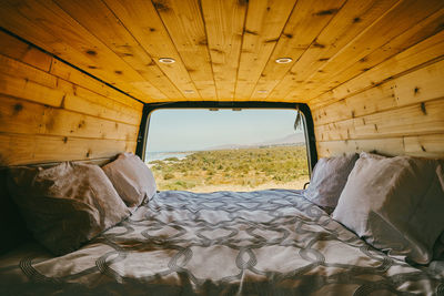 View of ocean during day from bed of camper van in baja, mexico.