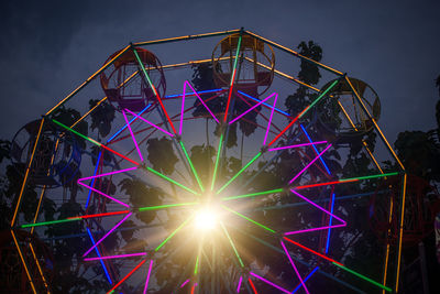 Low angle view of illuminated ferris wheel against sky at night