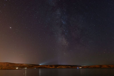 Scenic view of lake against star field against sky at night