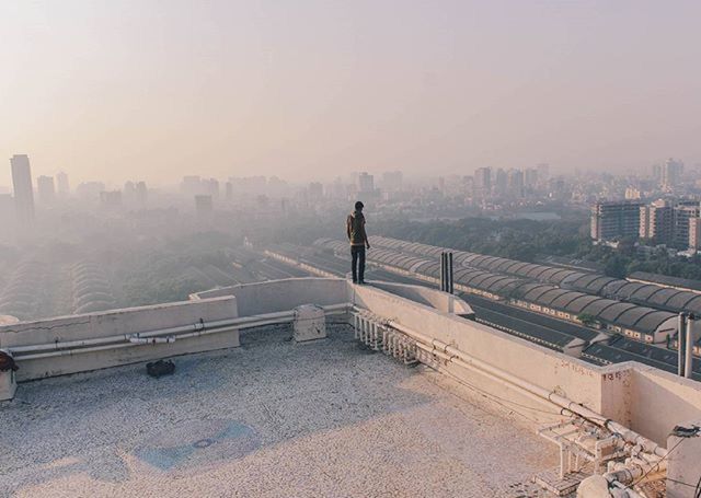 architecture, built structure, city, building exterior, railing, lifestyles, full length, cityscape, rear view, clear sky, men, bridge - man made structure, city life, leisure activity, transportation, standing, copy space