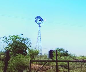 Low angle view of windmill against blue sky