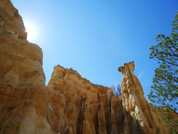 Low angle view of rock formation against clear blue sky