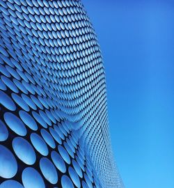 Low angle view of modern building against blue sky