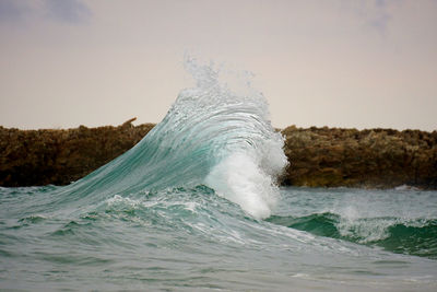 Water splashing in sea against sky